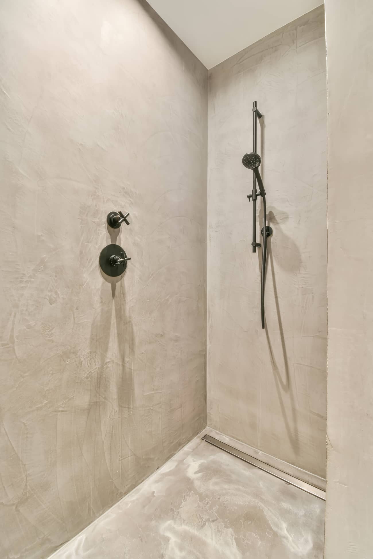 Renoviertes Badezimmer mit Mikrozementdusche auf Boden und Wänden