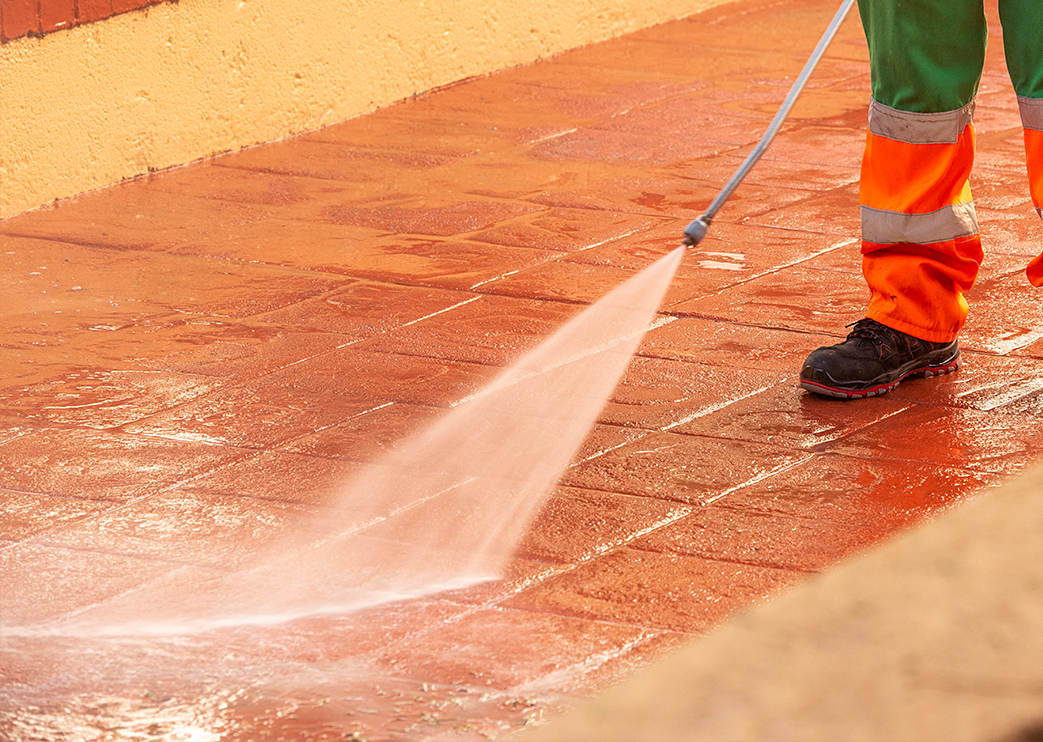 Arbeiter reinigt bedruckten Betonboden