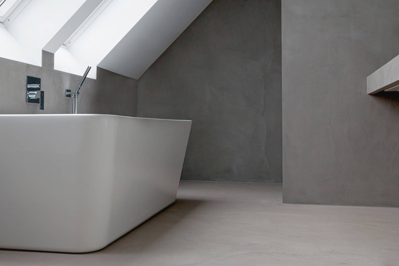 Bathroom with grey microcement on walls and floor.