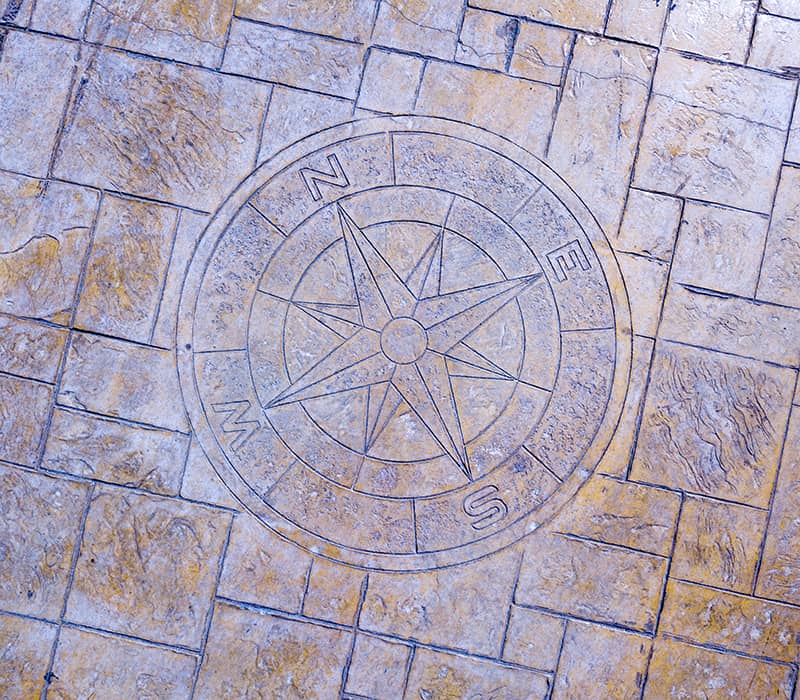 Imprinted concrete in garden with compass rose mould