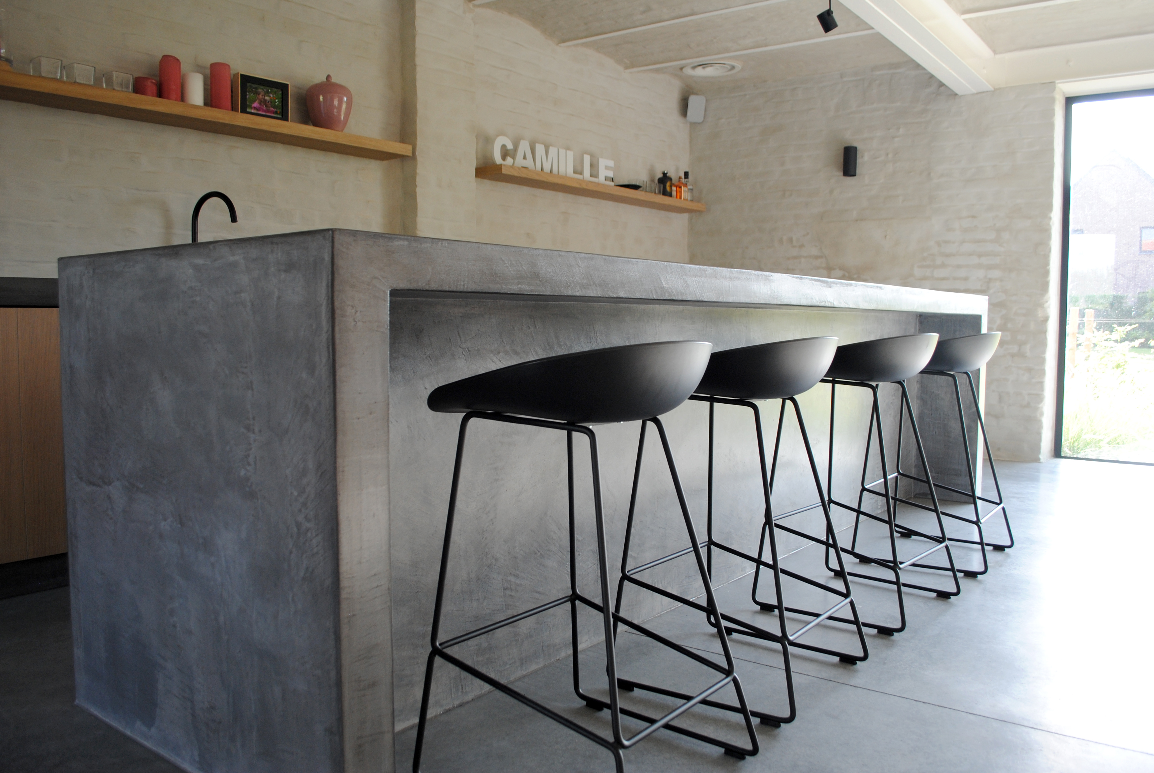 Open-plan grey microcement kitchen to the living room