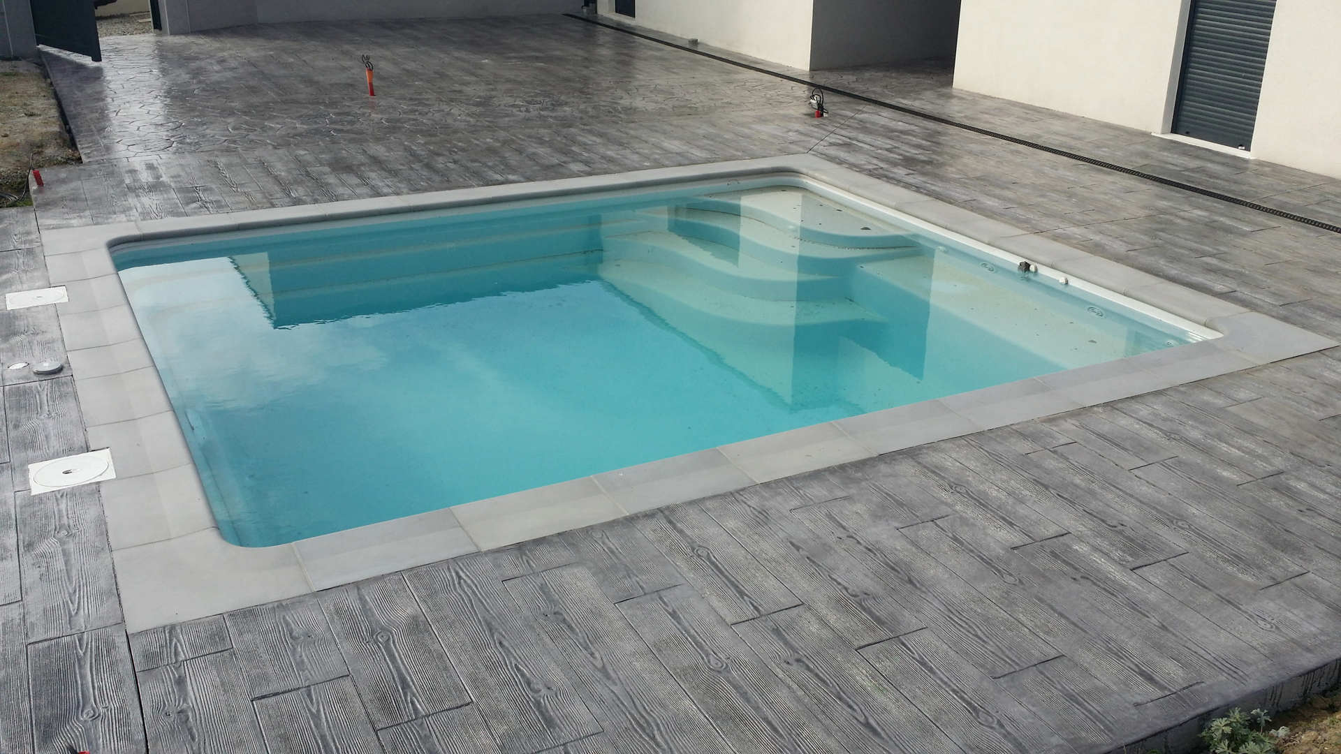 rectangular pool with wood imprinted concrete pavement