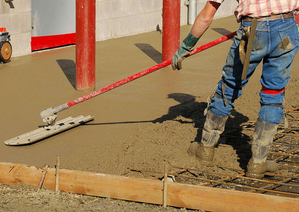 Operator troweling concrete floor