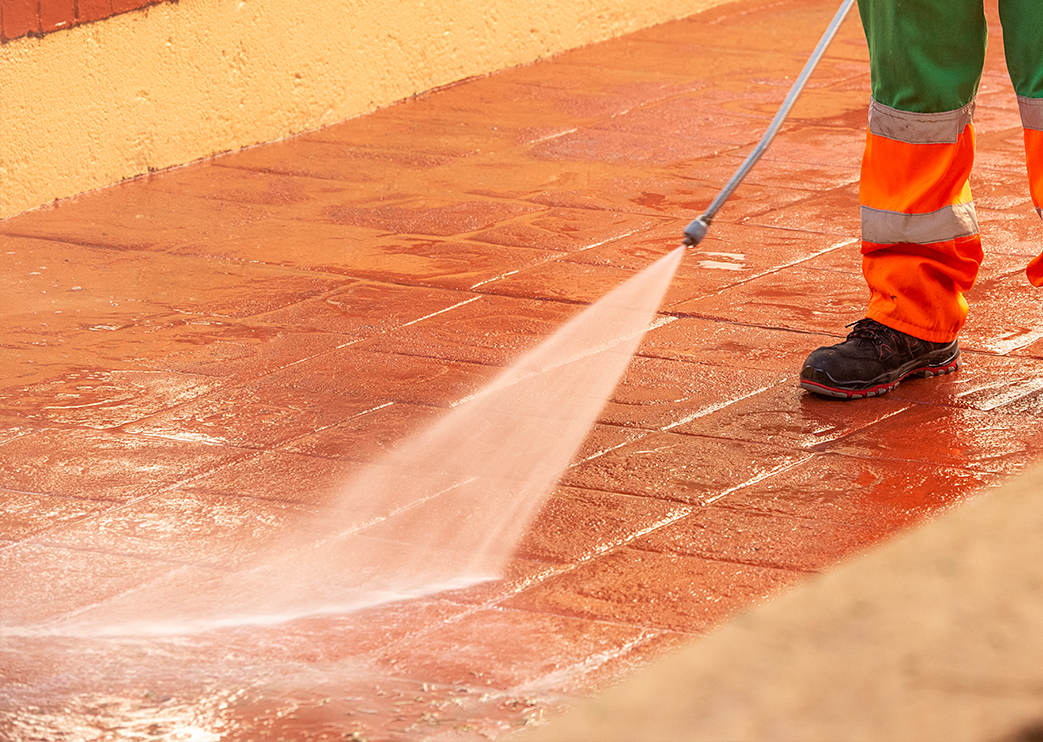 Operator cleaning imprinted concrete pavement