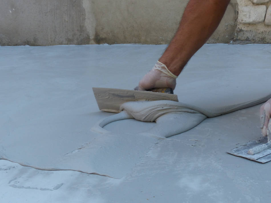 Professional applying microcement on floor