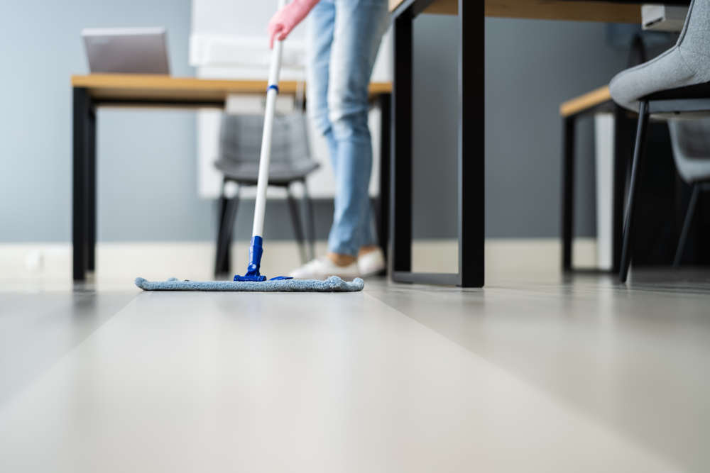 Hombre limpiando piso de cocina de microcemento