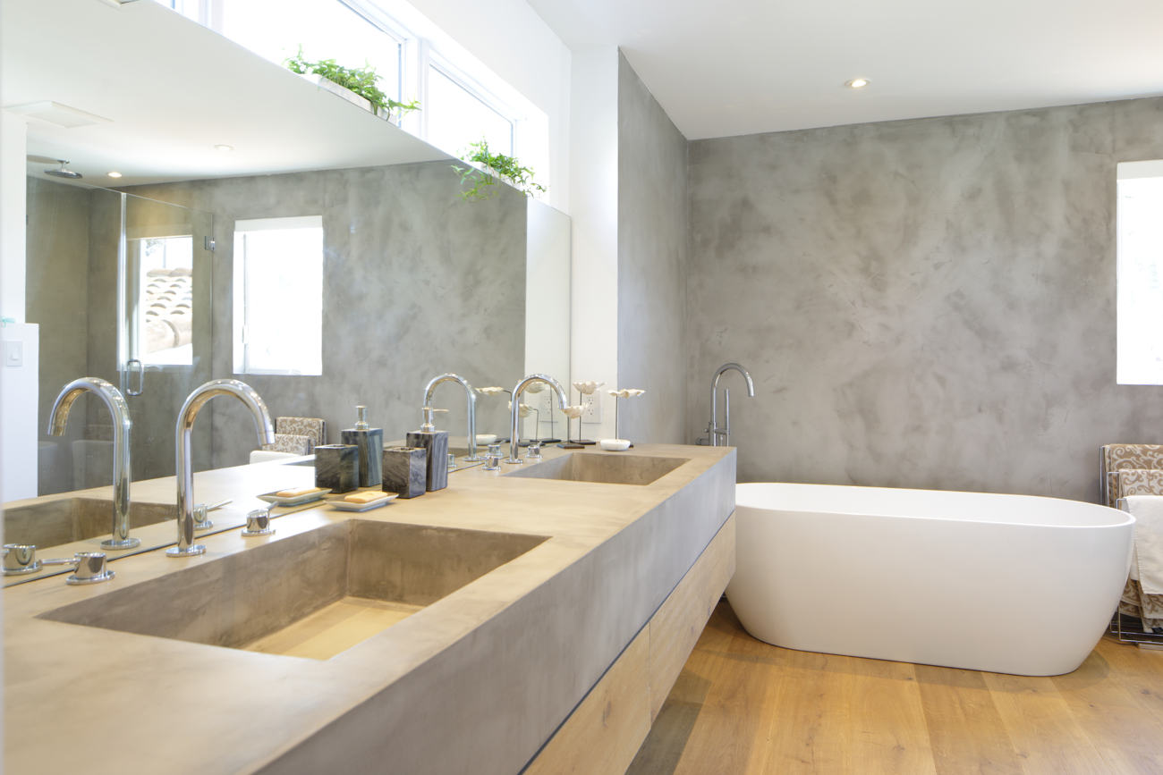 Kylpyhuone harmaalla mikrosementillä seinässä.