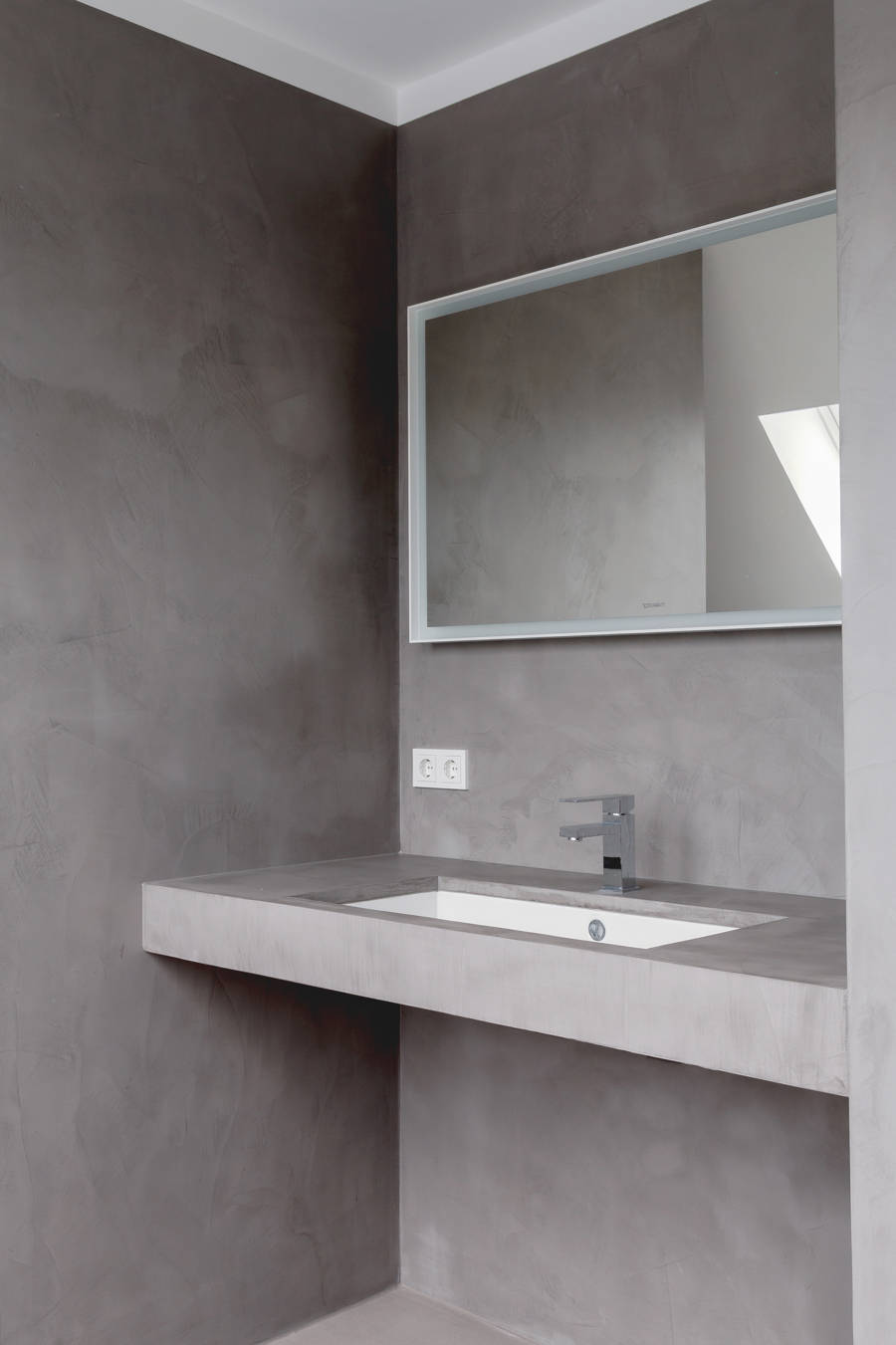 Kylpyhuone harmaalla mikrosementillä seinissä, lattiassa ja työtasossa.