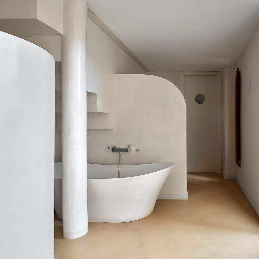 Microciment sur les murs, le sol et la colonne dans une salle de bain de Casa Isabel.