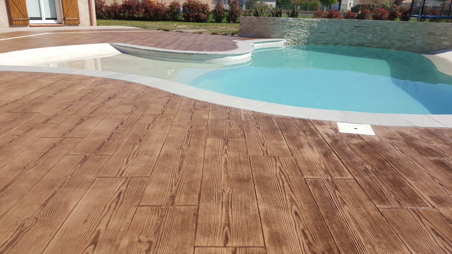 pavé en béton imprimé bois autour de la piscine