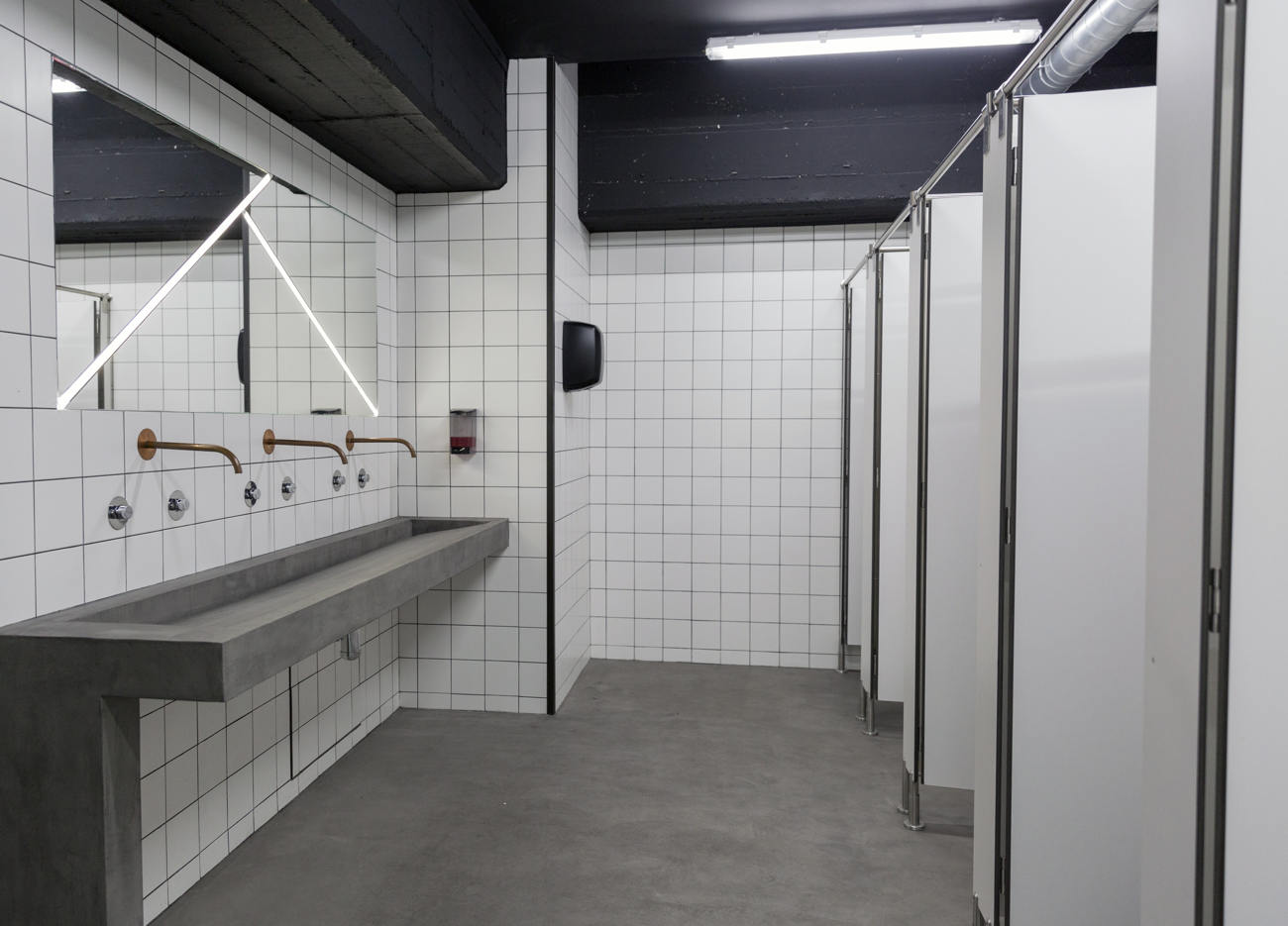 Salle de bain avec microbéton au sol et lavabo.