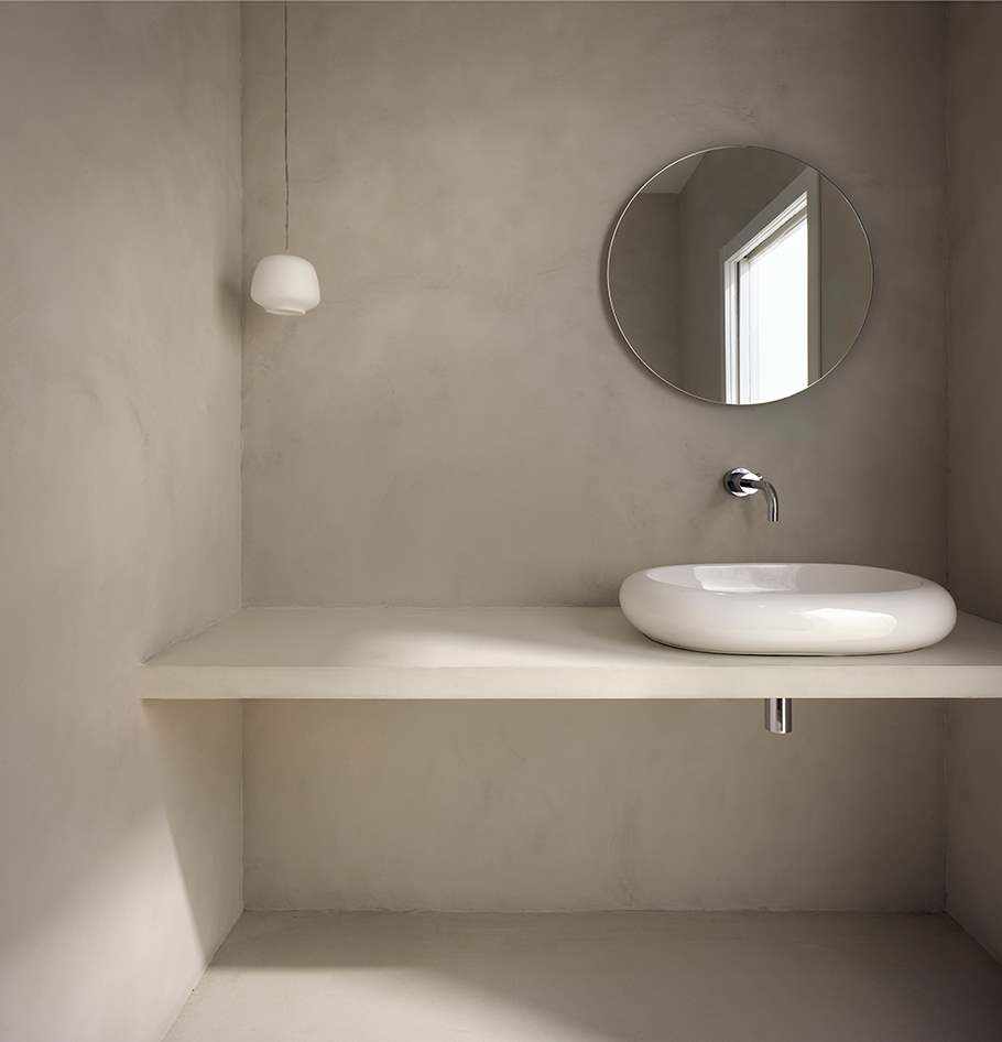 Microciment sur le mur et le comptoir dans la salle de bain dans le projet Imasi.