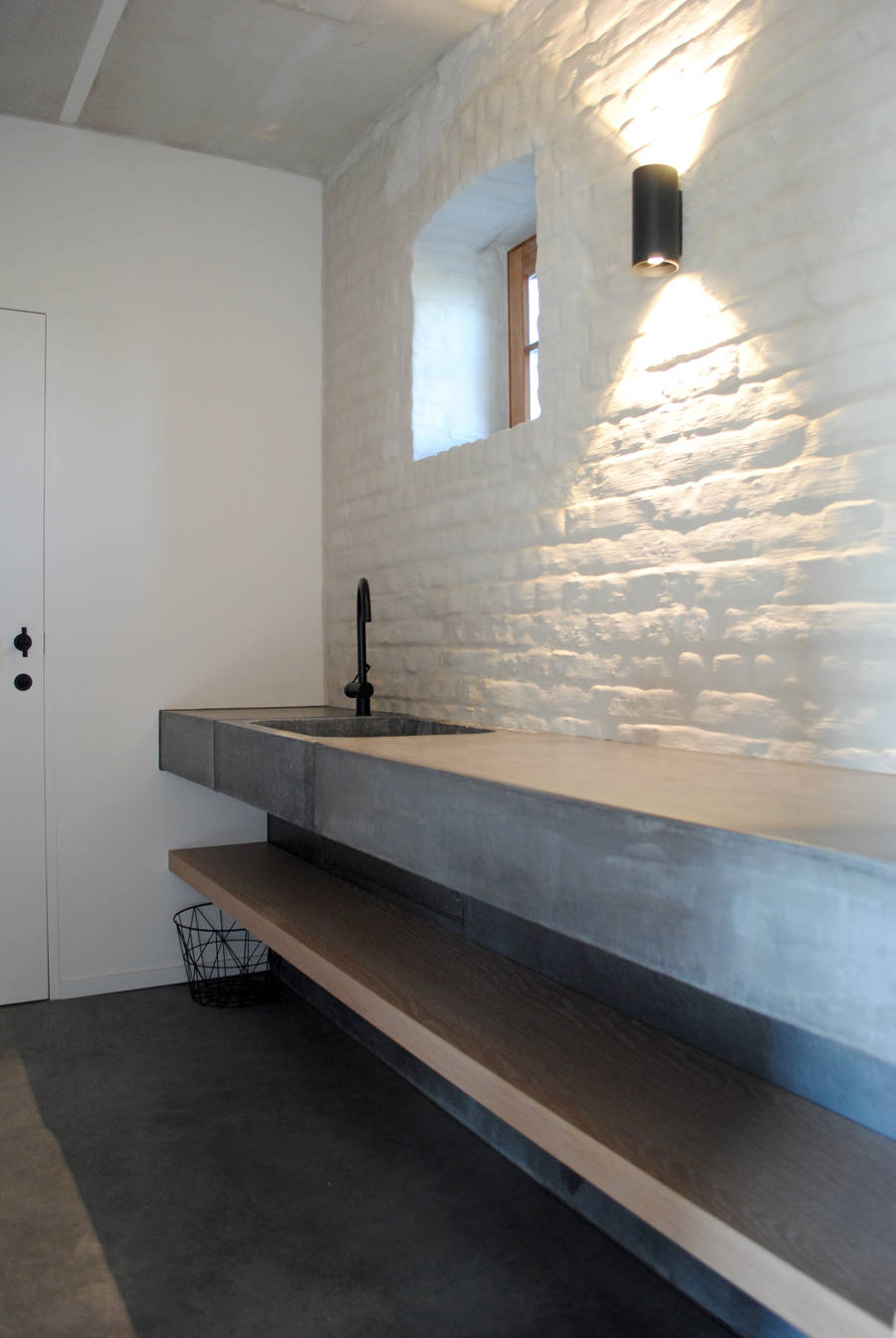 Salle de bain avec microciment sur le comptoir et dans le lavabo.