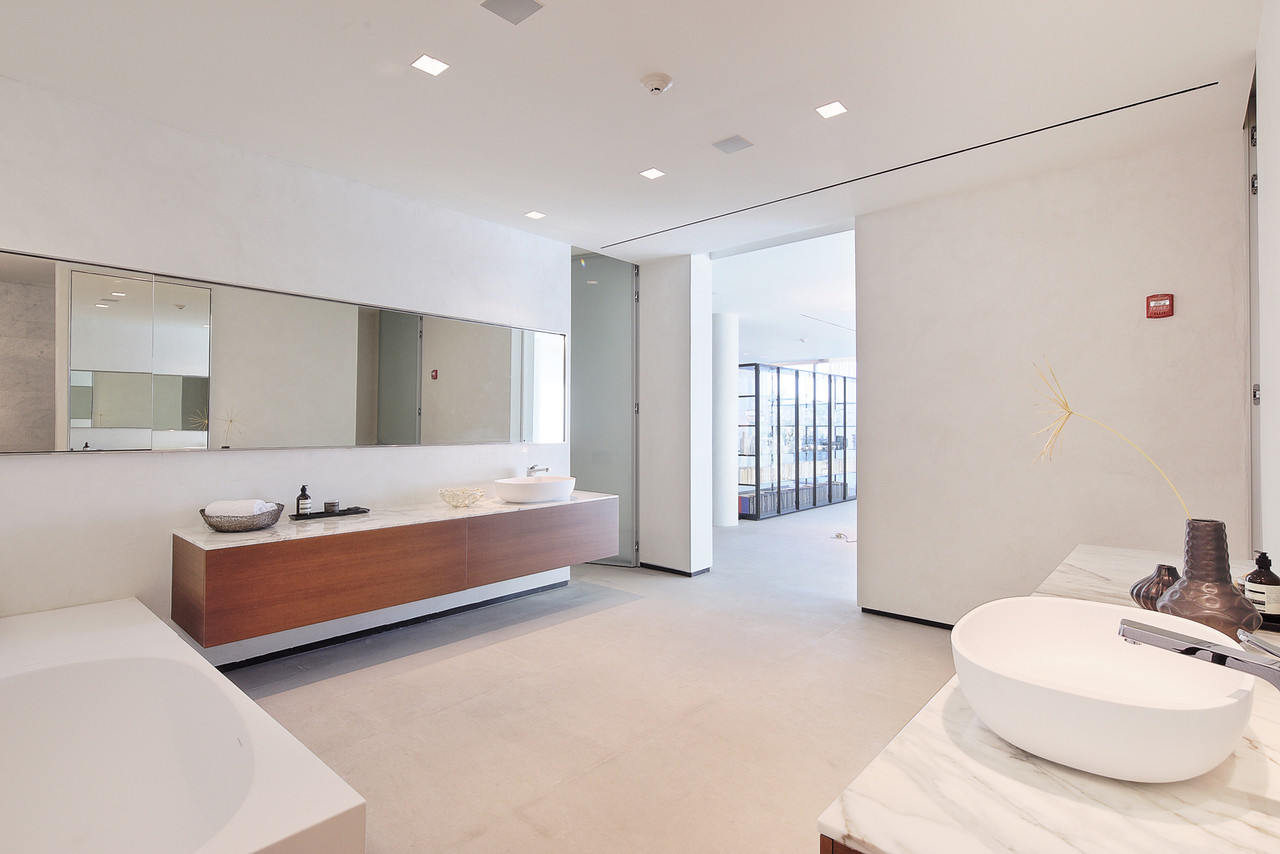 Fehér színű mikrocement fürdőszoba a falakon.
