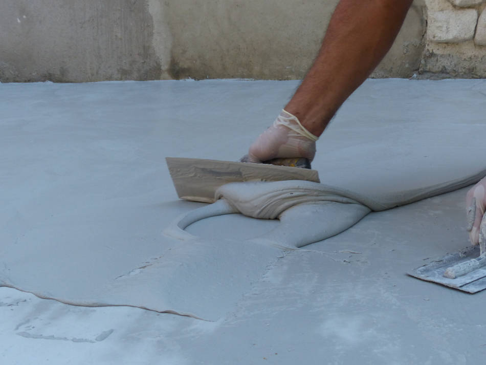 aplicación microcemento suelo con llana Profesional aplicando microcemento en suelo