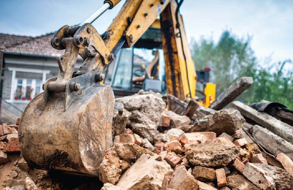 Excavator removing rubble during a demolition, waste that can be sorted and recycled.