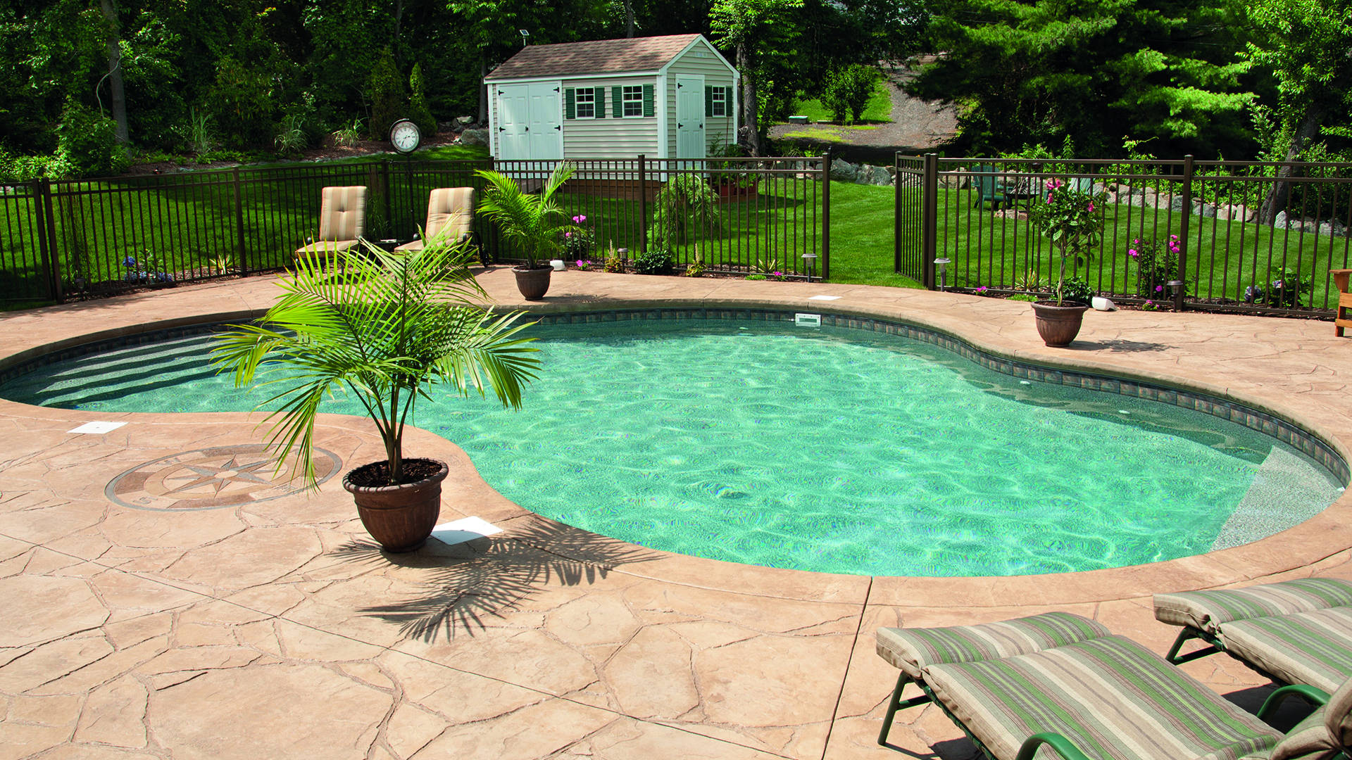 stamped concrete swimming pool with garden area 