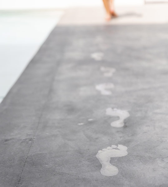 Intorno alla piscina rivestita con microcemento Atlanttic.