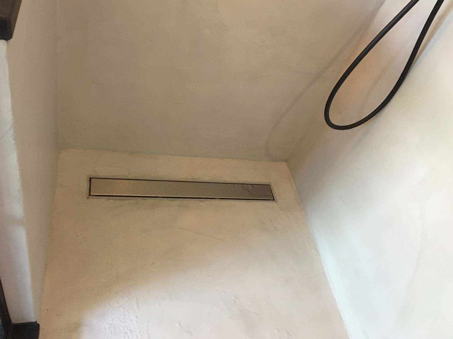 Microcement op de vloer en muur van een douche in Nederland.