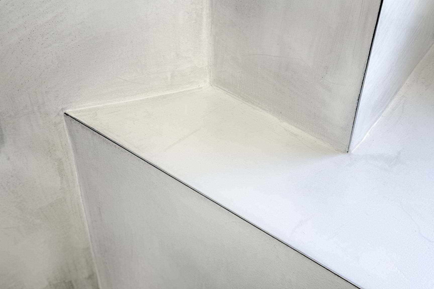 Mikrocement na ścianie i półce w łazience w projekcie Malermeister.