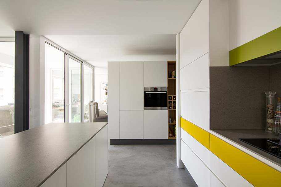 Bucătărie renovată cu microciment pe podea și blat de culoare gri.
